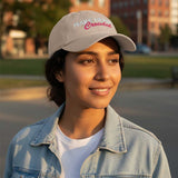 Woman wearing a cap with text "make heaven crowded", standing outdoors in a casual setting